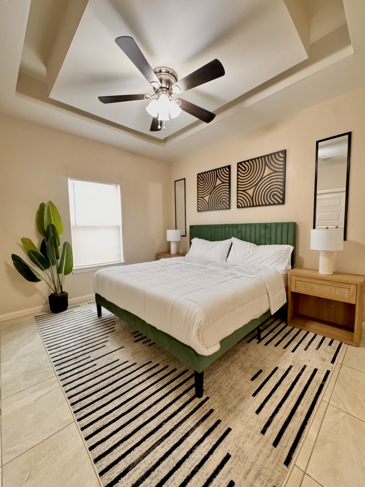 Airbnb emerald bedroom styled with white bedding and wood nightstands