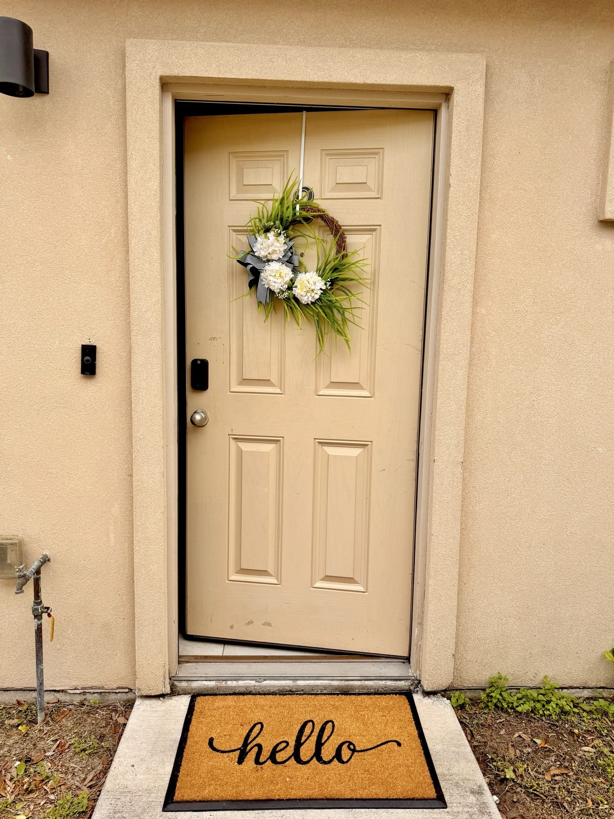 Airbnb front entry with wreath and hello doormat