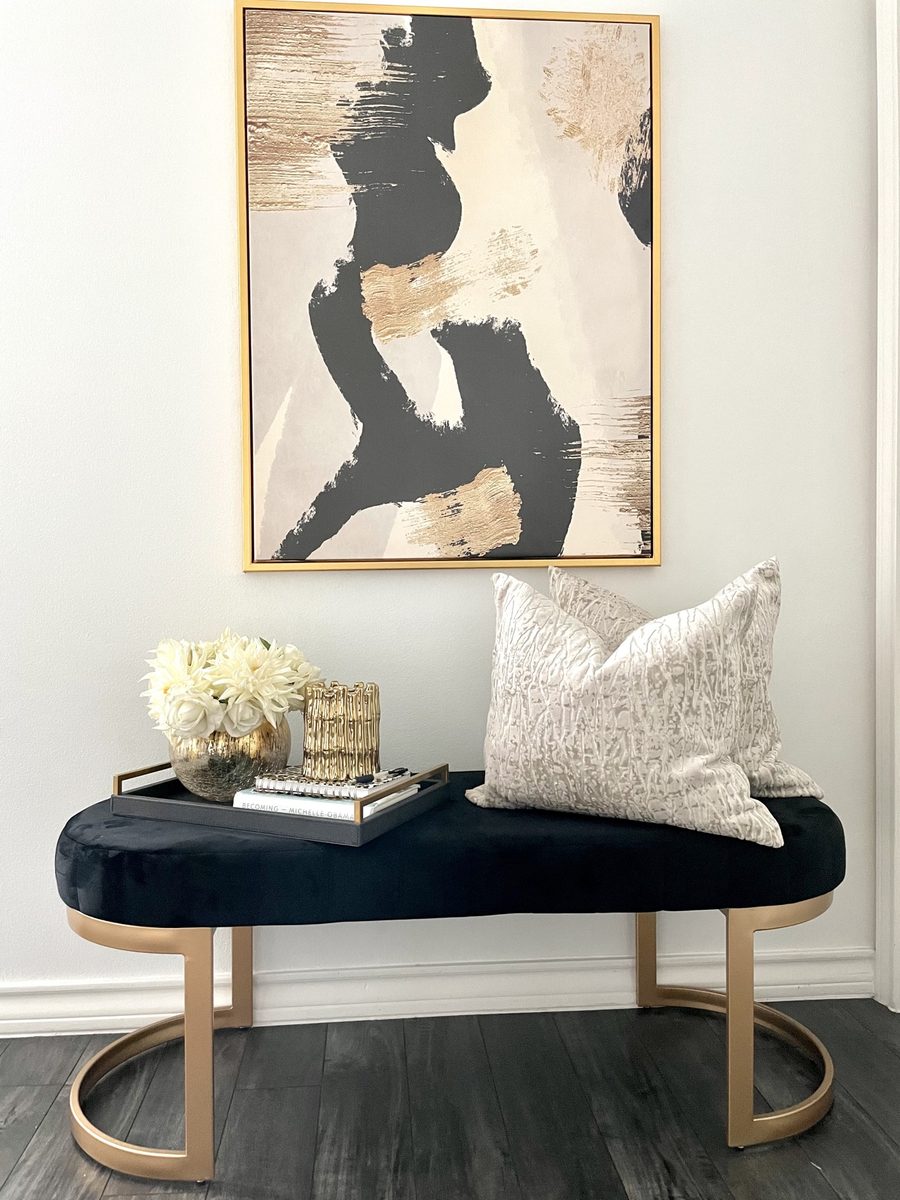 Entryway vignette with black velvet bench and abstract art