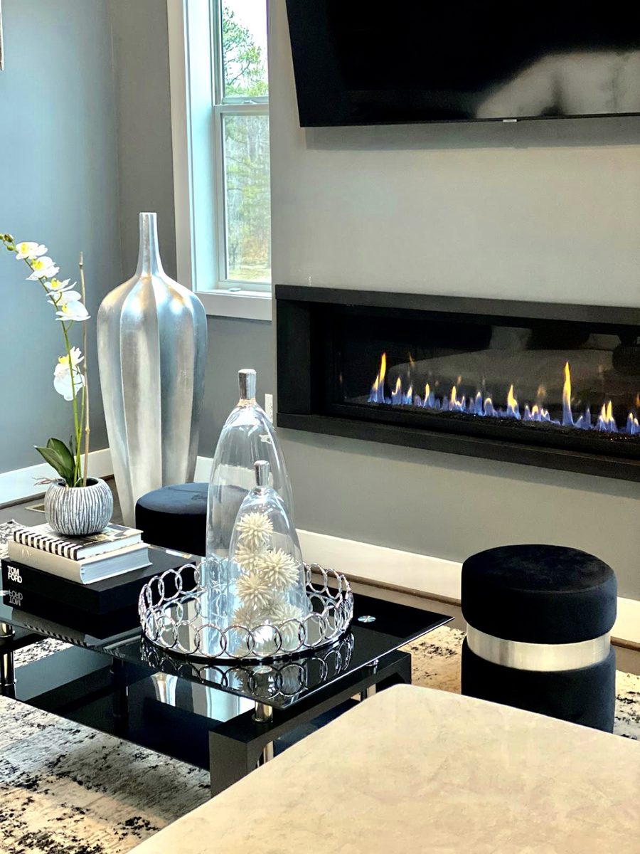 Styled linear fireplace with orchids, cloches and art books