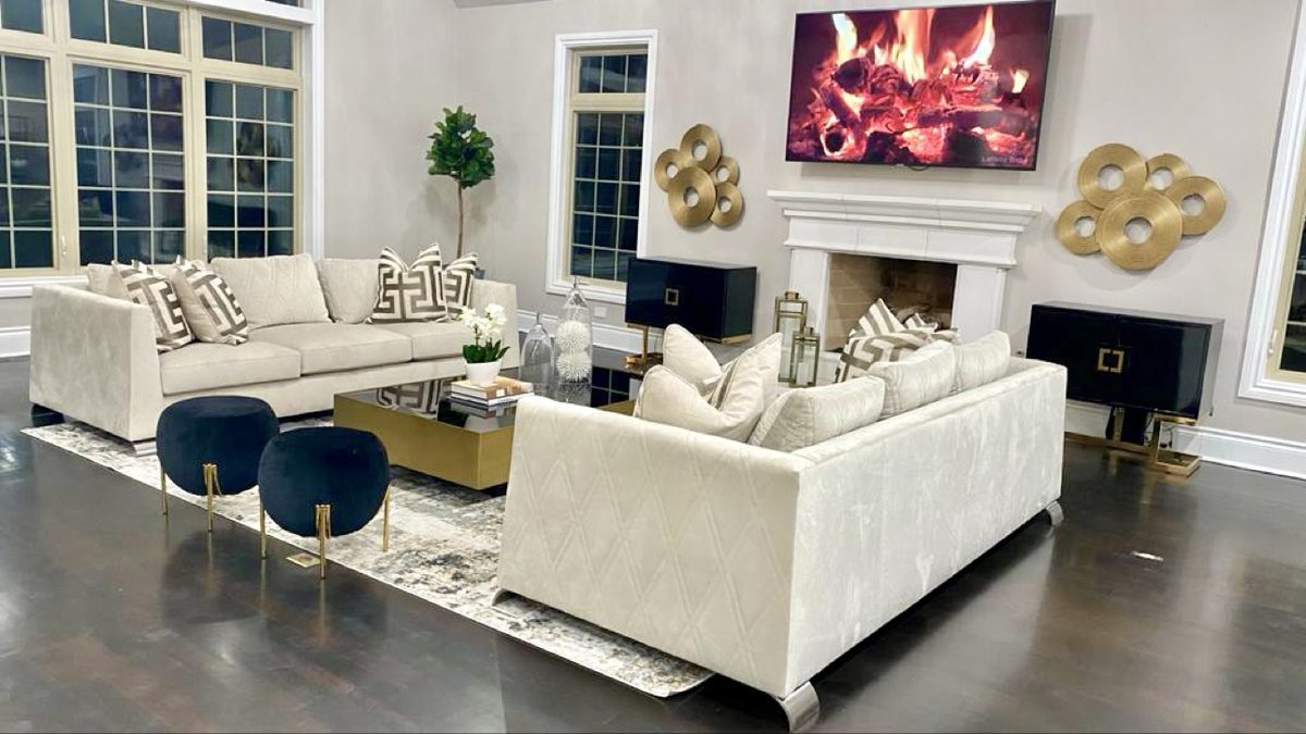 Glamorous living room with white sofas, black cabinetry and gold accents