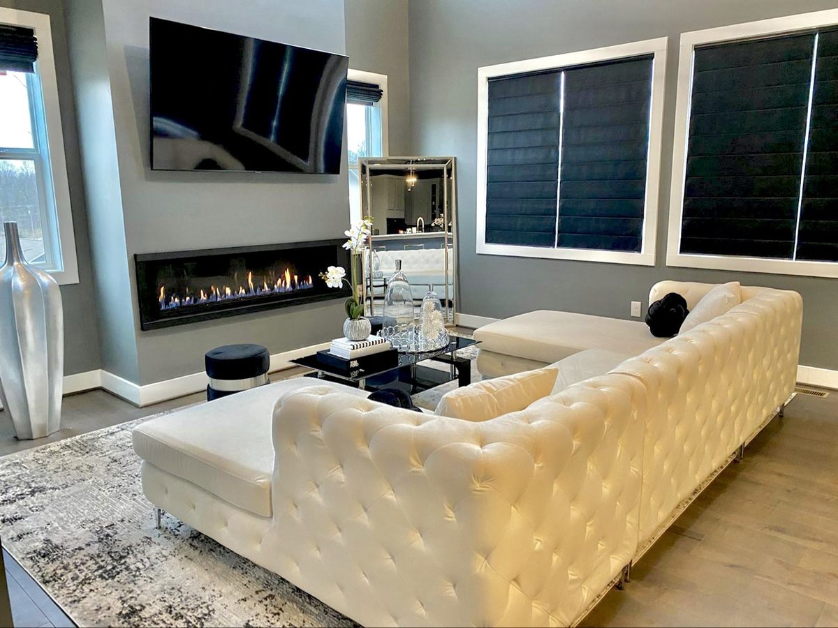 Bright living room with white tufted sectional and linear fireplace