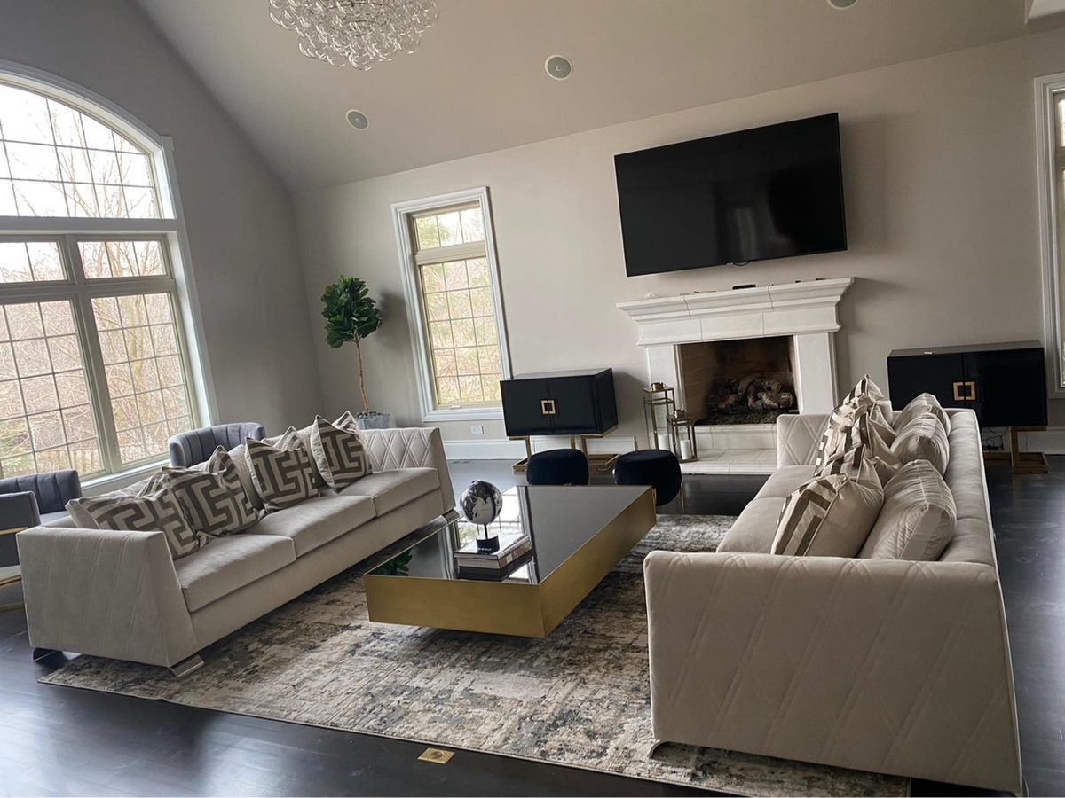 Vaulted living room with two beige sofas and black and gold coffee table